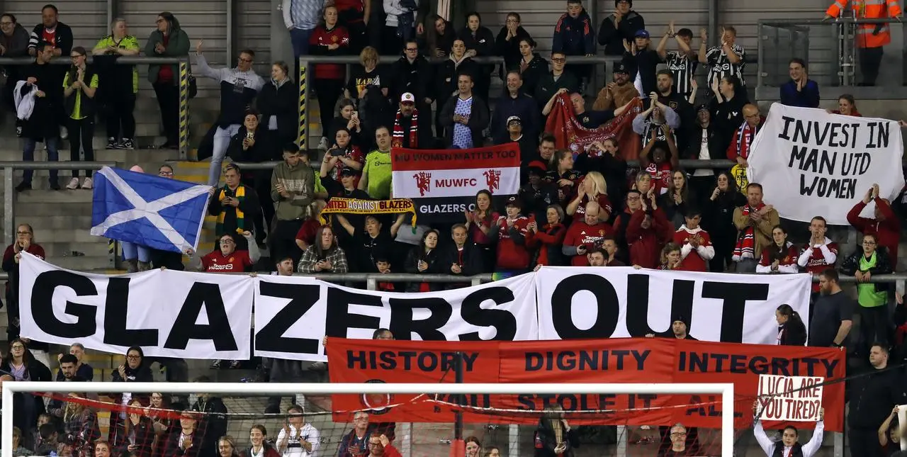 Fans hold up a 'Glazers Out' banner in the stand behind a goal
