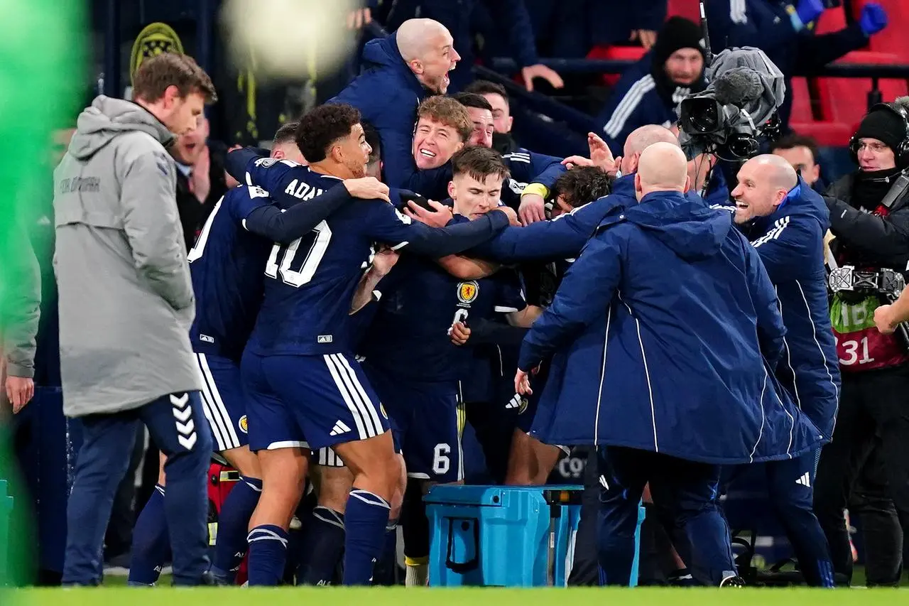 Scotland players and staff embrace after Kieran Tierney's goal