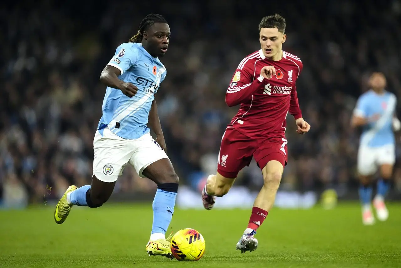 Manchester City’s Jeremy Doku is followed by Liverpool’s Florian Wirtz 