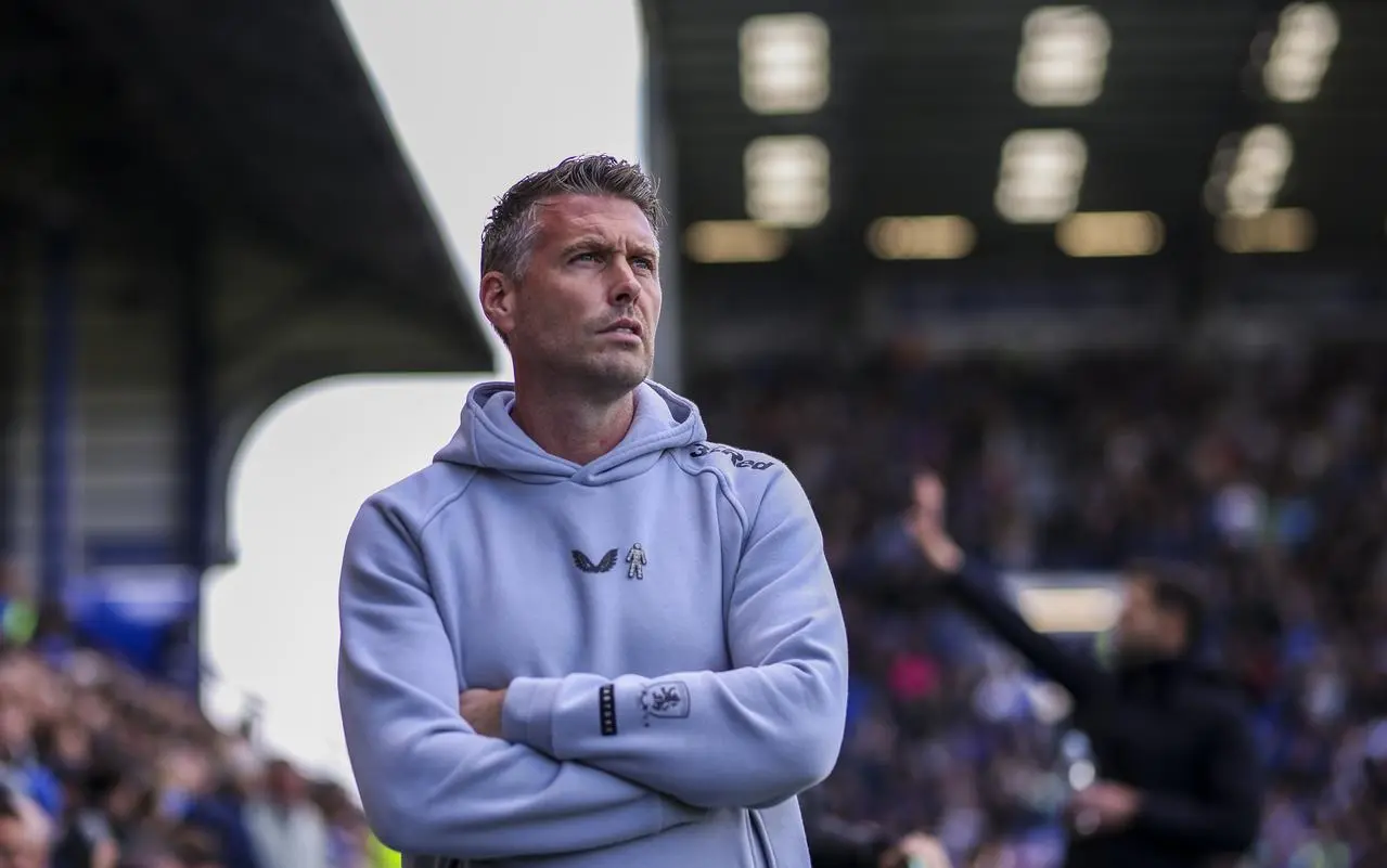 Rob Edwards stands with his arms folded