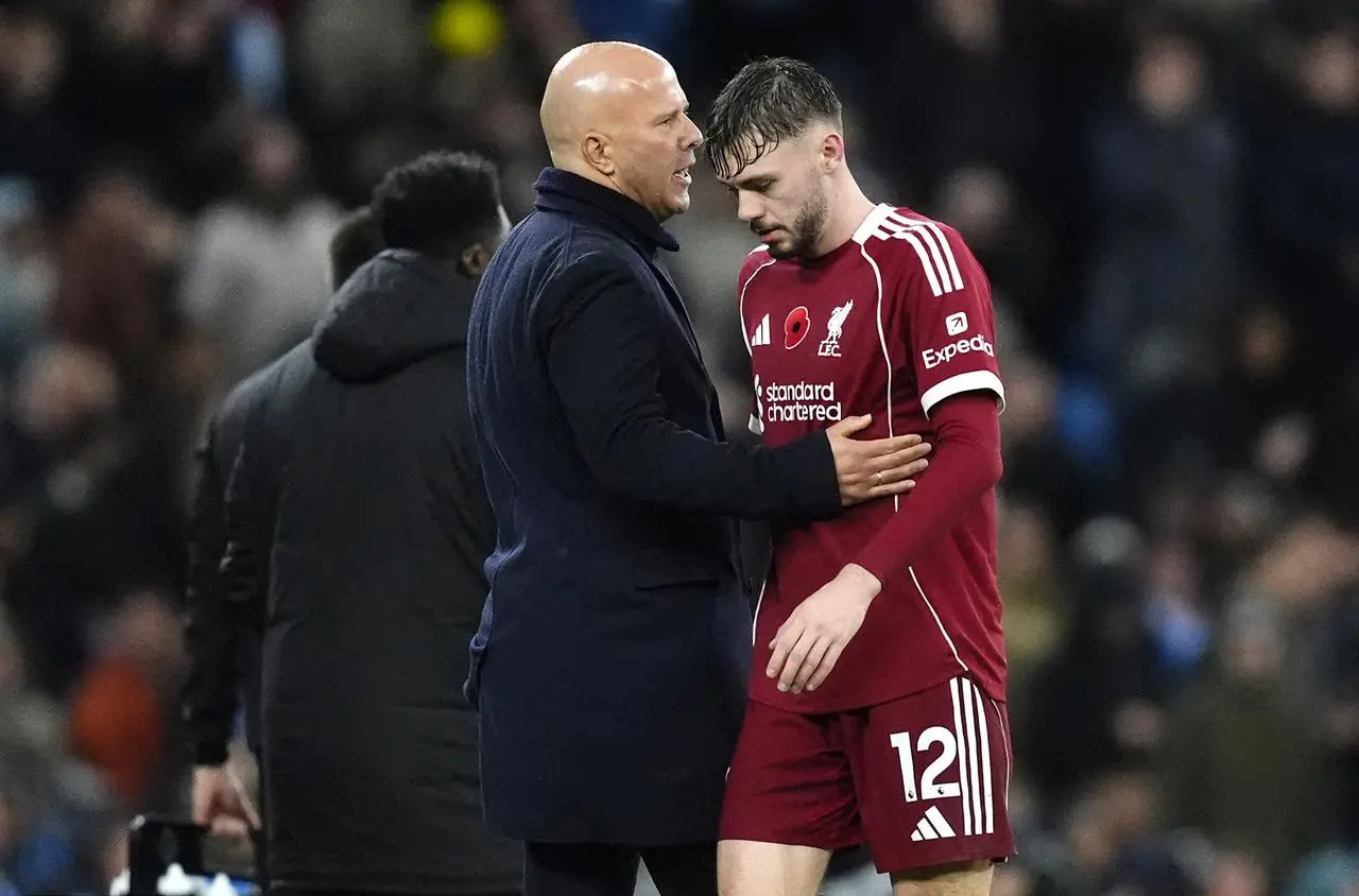 Liverpool head coach Arne Slot consoles Conor Bradley after being substituted 
