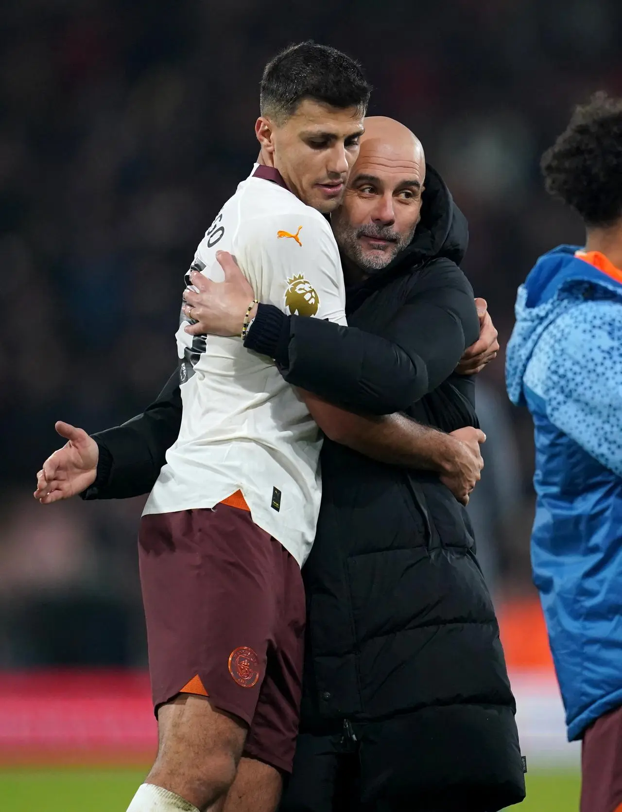 Manchester City manager Pep Guardiola, right, embraces midfielder Rodri