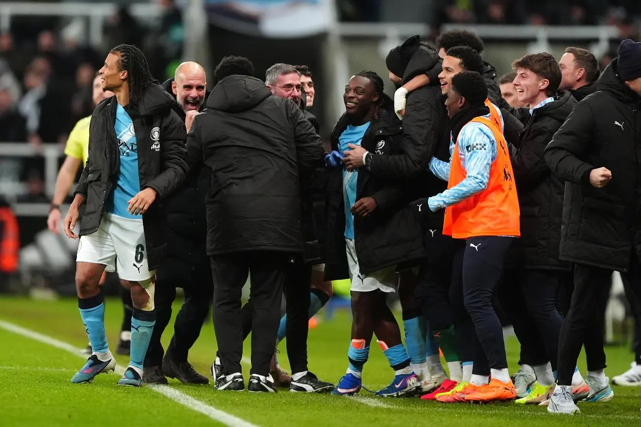 Manchester City manager Pep Guardiola, second left, and his players celebrate their second goal scored by Rayan Cherki, not pictured