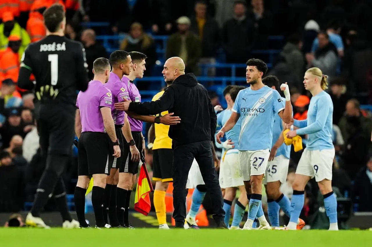 Pep Guardiola with referee Farai Hallam following the Premier League match against Wolves