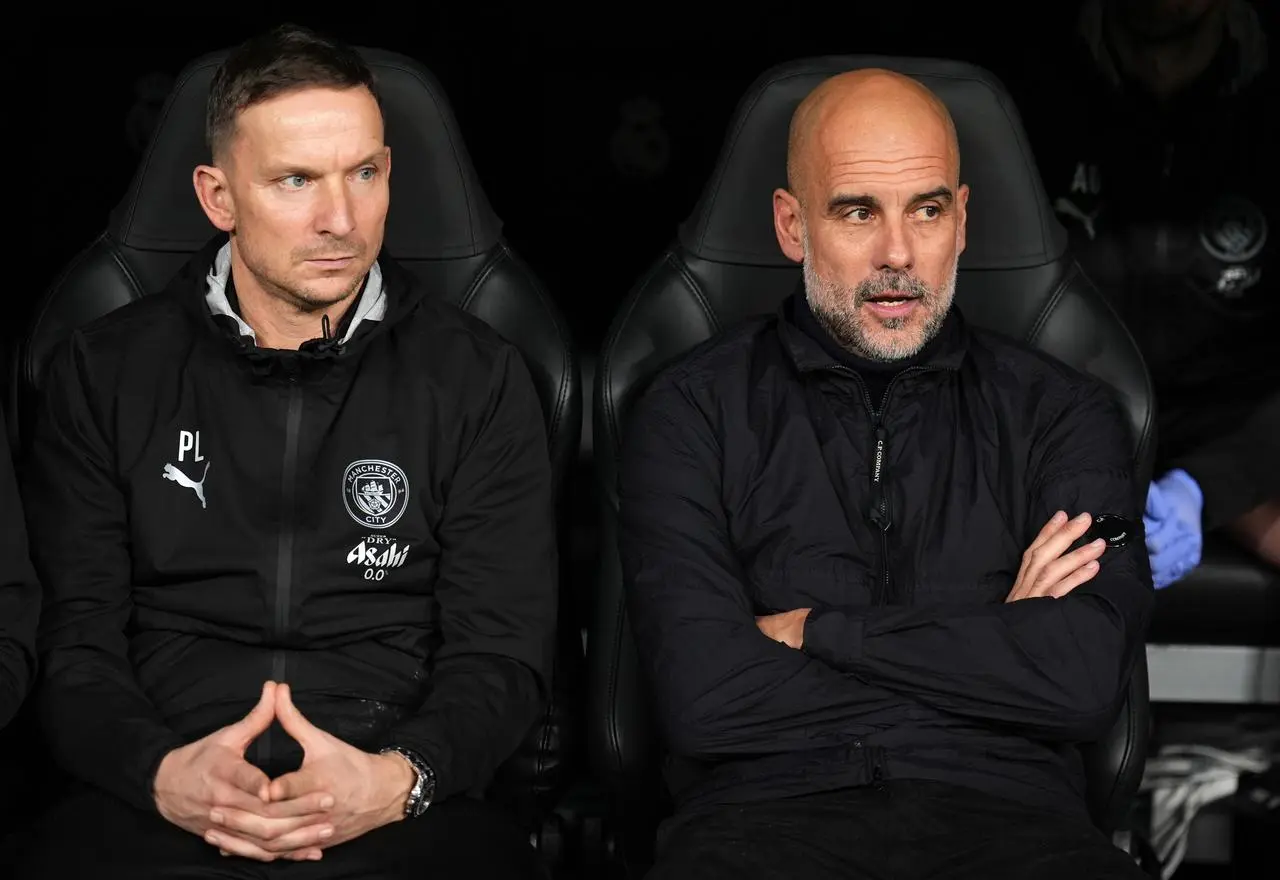 Pep Guardiola (right) sitting with assistant Pep Lijnders 