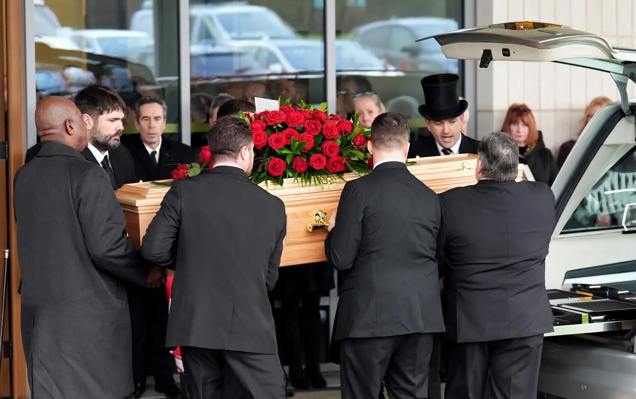 The coffin of John Robertson is carried into Rushcliffe Oaks Crematorium, Nottingham