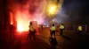 Police attempt to put out flares that have thrown towards them outside the stadium before the UEFA Europa Conference League 